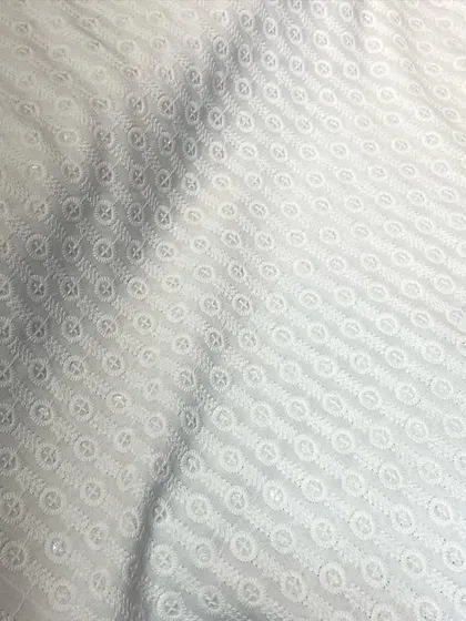 An elegant white-on-white Chikankari fabric with a circular embroidery pattern. This is a timeless option for a classic kurta pyjama set.