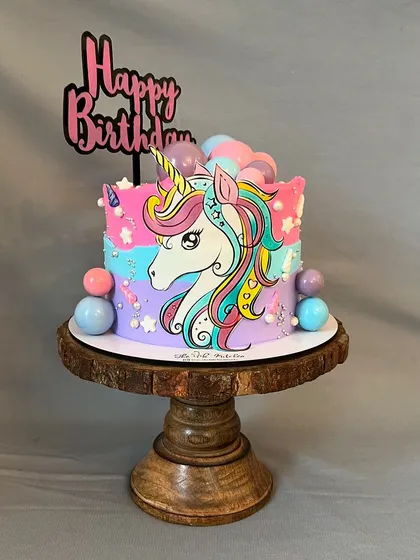 A different take on the unicorn theme, this cake features a hand-painted unicorn on a colorful buttercream background, decorated with stars and bubbles.