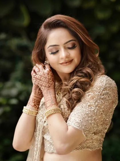 A beautiful candid of the bride getting ready. The soft, golden eye makeup and loose curls create an ethereal and elegant style.