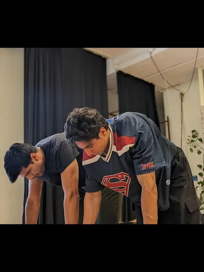 Two students focus on a plank variation, building the core and upper body strength essential for contemporary dance.
