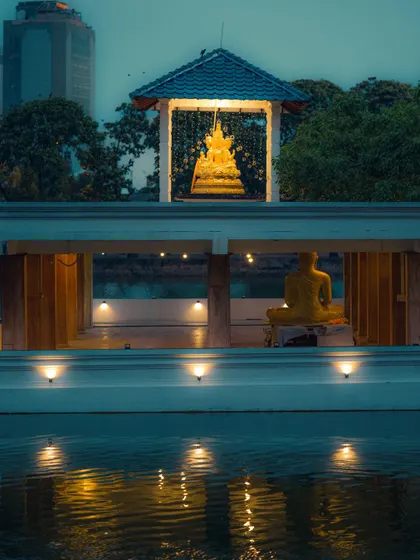 A serene evening shot of the Seema Malaka temple in Colombo. The composition layers two Buddha statues with their reflections in the water, showcasing my eye for symmetry and tranquil travel photography.