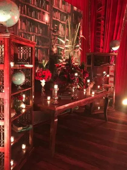 This corner of the vintage library-themed wedding features antique-style wooden shelves, globes, and floral arrangements. These themed nooks provide great photo opportunities and make the overall decor feel more immersive and detailed.