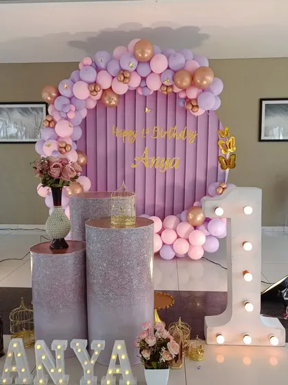 The complete setup for Anya's first birthday, including the velvet backdrop, marquee letters and number, and themed pedestals.