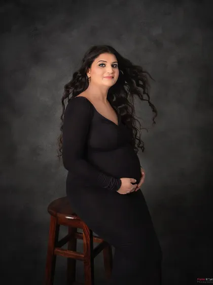 A simple yet powerful seated portrait. The mom-to-be's flowing hair and direct gaze create a feeling of confidence and strength in this classic black and white shot.