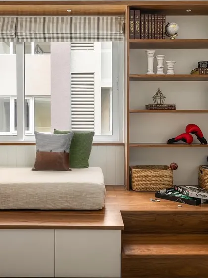 Another view of the multi-functional room in 'Palaash', showing the stepped platform bed with built-in storage and an integrated library unit. It's a perfect blend of elegance and quirk.