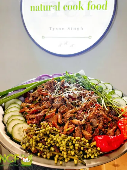 My spicy chicken 'singju', a non-veg version of the classic salad, garnished with fresh herbs, cucumber, and king chillies.