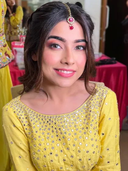 A bright and happy smile from the bride-to-be. The makeup is kept light and radiant to match the cheerful atmosphere of a Haldi event.