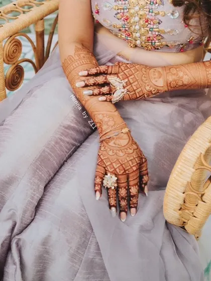 A full view of the bride's mehendi, showing off the fantastic stain color that complements her pastel outfit.