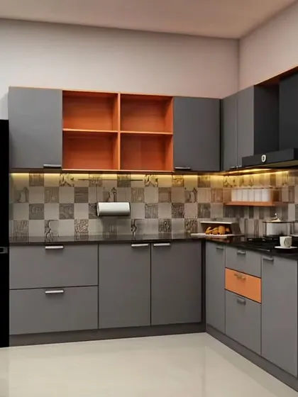 A modern L-shaped kitchen with grey cabinets and a pop of orange in the open shelving units.