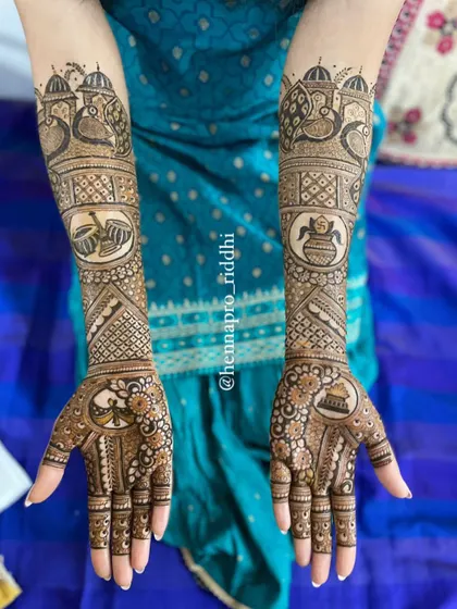 Not every bride wants figures in her henna, and that's beautiful too. This design uses traditional motifs like peacocks, ceremonial drums (dhol), and the sacred pot (kalash) to create a full bridal look.