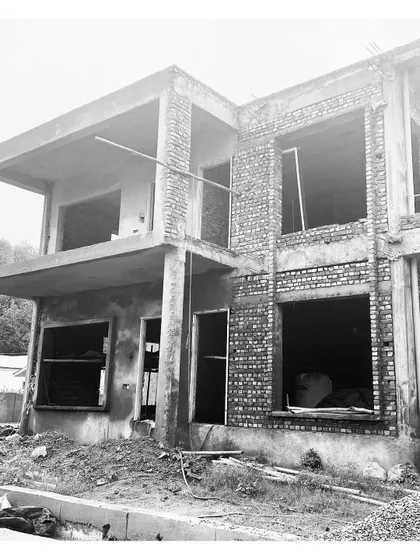 A villa in Dehradun under construction. This black and white photo emphasizes the form and texture of the raw brick and concrete structure.