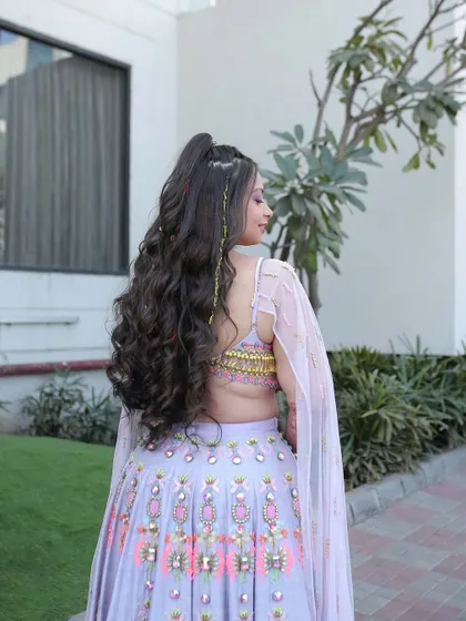 A side view of the carnival hairstyle, showing the height of the half-ponytail and the beautiful cascade of curls. This style is all about volume and movement.