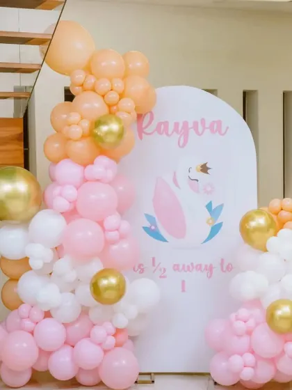 A 'Half way to 1' celebration for baby Rayva. The pink, peach, and white balloon garland is a simple yet beautiful way to mark the six-month milestone.