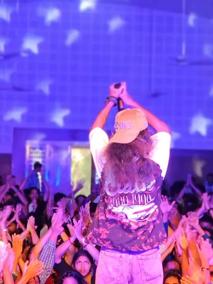 Leading the crowd in a clap-along, creating an interactive and unified moment.