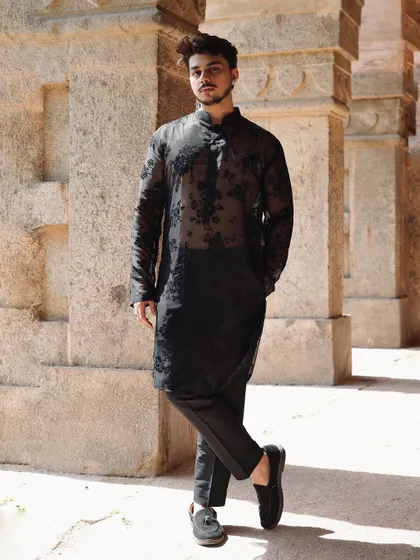 A full-length view of the sheer black floral kurta. Paired with simple black trousers, this outfit is all about embracing timeless elegance with a contemporary, edgy twist.