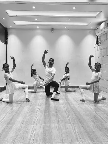 A group of young ballerinas in a synchronized pose with me during a class. These photos show the discipline and coordination we build in our ballet program.
