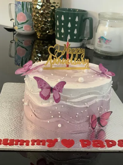 A pretty anniversary cake with a purple ombre effect. The cake is decorated with delicate butterflies and a message for "Mummy & Papa."