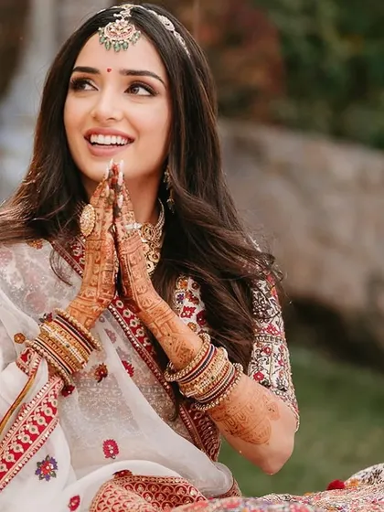 A candid moment of prayer. The bride's makeup is soft and respectful of the traditional ceremony.
