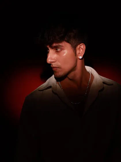 A profile shot that showcases the model's strong features against a dark, moody background. The red glow adds a subtle hint of color and drama.