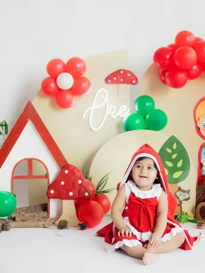Our Little Red Riding Hood is ready for her first birthday adventure. This storybook theme comes to life with a custom-designed backdrop, props, and a cute hooded outfit.