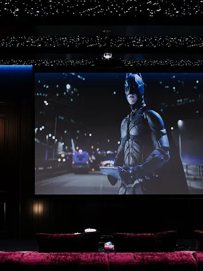 Transform your movie nights with a custom-designed home theatre. This one features grey and maroon tones, a cozy lounge sofa, and a star-like ceiling for the perfect cinematic ambiance. It's more than a space; it's an experience.