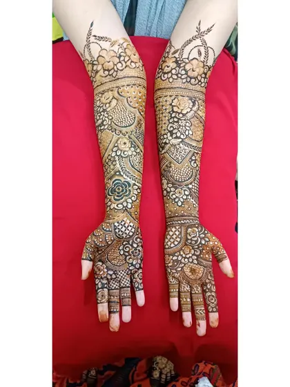 A full-arm bridal design with a beautiful arch of flowers at the top, framing the intricate patterns below.