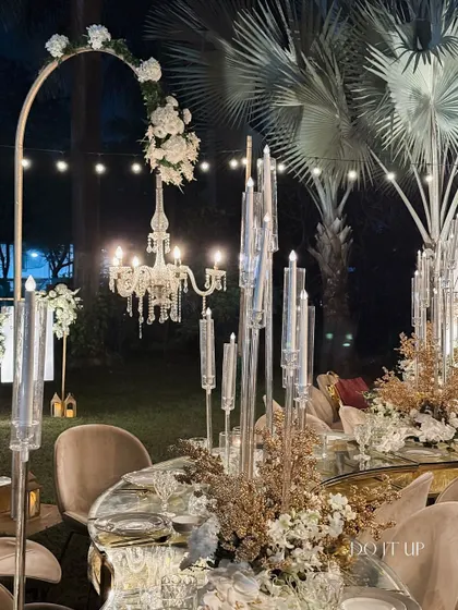 Another view of the glamorous mirrored table, showing the arched floral stands with hanging chandeliers. This adds height and drama to the overall reception decor.