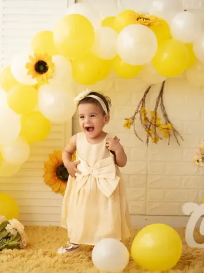 An expressive, happy moment from the yellow-themed first birthday session. We aim to capture the genuine joy of your child's special day.