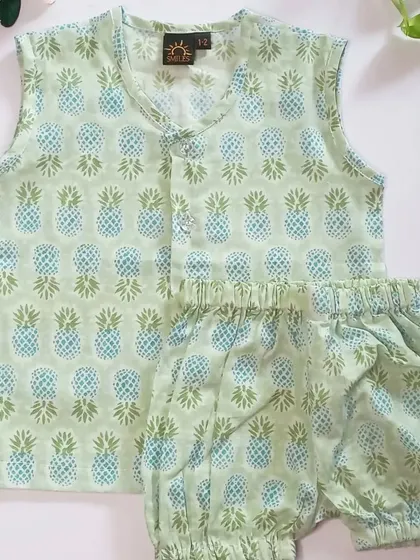 A flat-lay of the pineapple print co-ord set, showing the block-printed details. This set is handmade with love and available for babies from 6 months to 2 years.