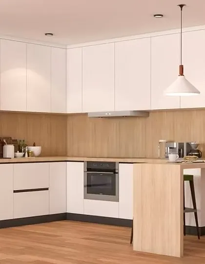 A clean and simple L-shaped kitchen with white cabinets and a light wood backsplash and countertop. A small peninsula provides a convenient breakfast spot.