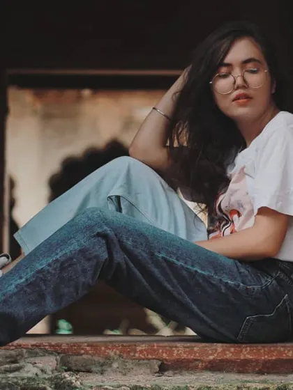 We used a stone window at a heritage site in Bharatpur as a natural frame for this lifestyle fashion shot. The model's relaxed, seated pose and casual outfit contrast beautifully with the ancient architecture, creating a modern vintage look.