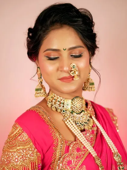 A stunning close-up of a bride in a vibrant pink saree. The focus is on her intricate jewelry, flawless makeup, and serene expression, capturing the essence of bridal beauty.