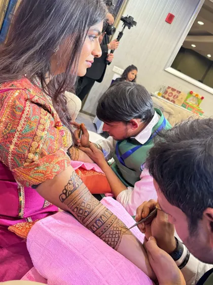 One of my team members applying mehandi to a guest at a wedding. We make sure everyone feels special.