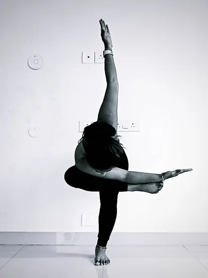 Creating shapes that challenge both balance and strength. This creative variation of a standing balance incorporates elements of a twist and a bind, requiring full-body awareness and control.