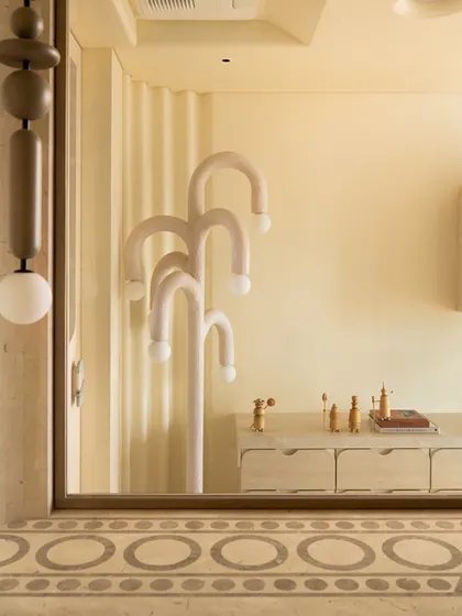 A whimsical floor lamp with multiple curved arms is reflected in a mirror, showcasing the playful geometry of the Soft Serve project.