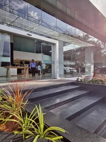 The entrance detail of a showroom, featuring landscaped planters and wide, welcoming steps. We believe thoughtful design extends to every detail, including the transition from the exterior to the interior.
