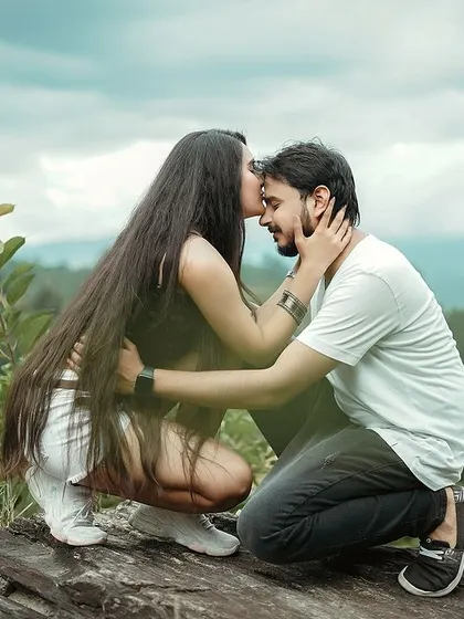 A quiet moment on a hilltop, away from everything. This candid couple photograph captures a gentle forehead kiss, a simple and powerful expression of love. We believe the most beautiful shots happen when you forget the camera is even there.