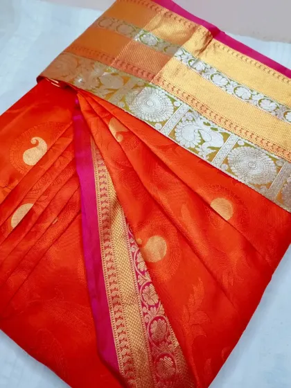 A vibrant orange and pink saree, pleated for a client's special occasion. My custom pleating service ensures a flawless drape for any body type.