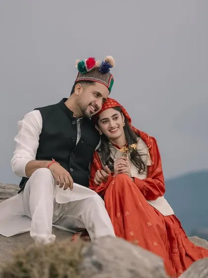 A sweet and tender moment with the couple seated on a rock, overlooking the valley. Her head rests gently on his shoulder, capturing their comfortable love.