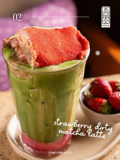 A Strawberry Dirty Matcha Latte from Mokai. The vibrant colors and fresh strawberry garnish make this a visually appealing and refreshing-looking drink.