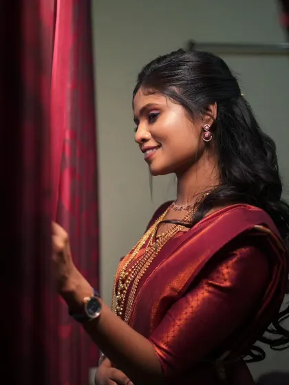 A beautiful reception look with a rich maroon saree and soft, flowing hair.