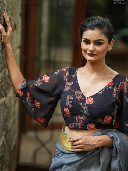 A floral georgette blouse with bell sleeves, paired with a simple grey saree.