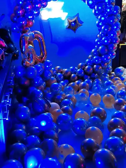 The same setup under blue lighting, creating a completely different mood. The metallic balloons reflect the light beautifully.