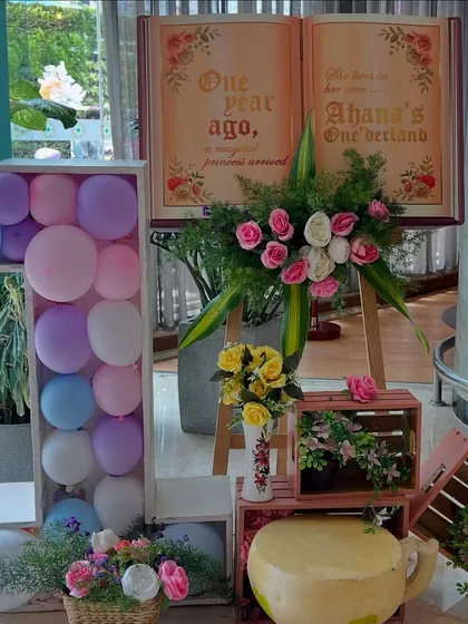 A close-up of the entrance decor for 'Ahana's Onederland', featuring a giant '1' filled with balloons and a storybook sign sharing a sweet message.