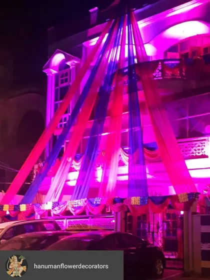 Here, I used bold blue and pink drapes with dramatic uplighting to make this house stand out for a night celebration. The fabric is draped from the roof down to the entrance, creating a tall, impressive look.