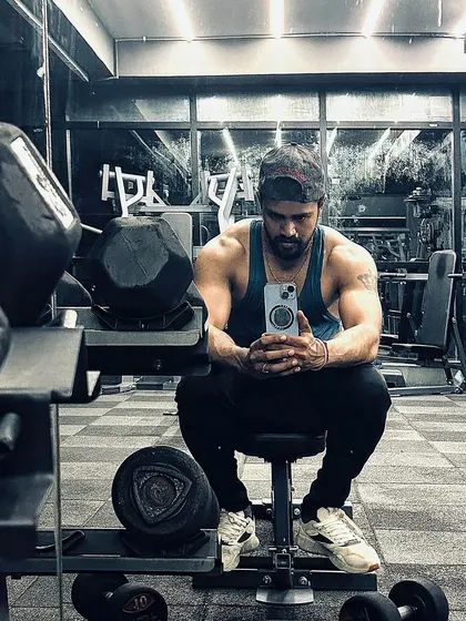 Taking a moment to rest between sets. Proper rest is just as important as the work itself for muscle growth, a principle I emphasize in my strength programs.