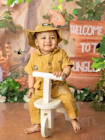 Our little jungle explorer is ready for an adventure! The safari outfit and his confident pose on the tricycle are perfect for this wild theme.