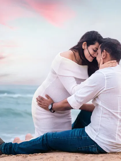 A passionate and romantic pose on the beach, capturing the deep love between the couple as they await their new arrival.