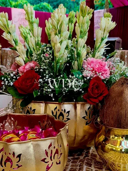 Traditional elements for the holy ceremony, including a coconut in a brass 'kalash' and bowls of flower petals, all in beautiful golden containers.