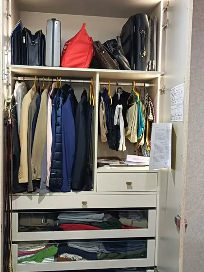 The interior of the delivered wardrobe, showcasing the functional organization system with hanging space, shelves, and pull-out drawers with glass fronts for easy visibility.
